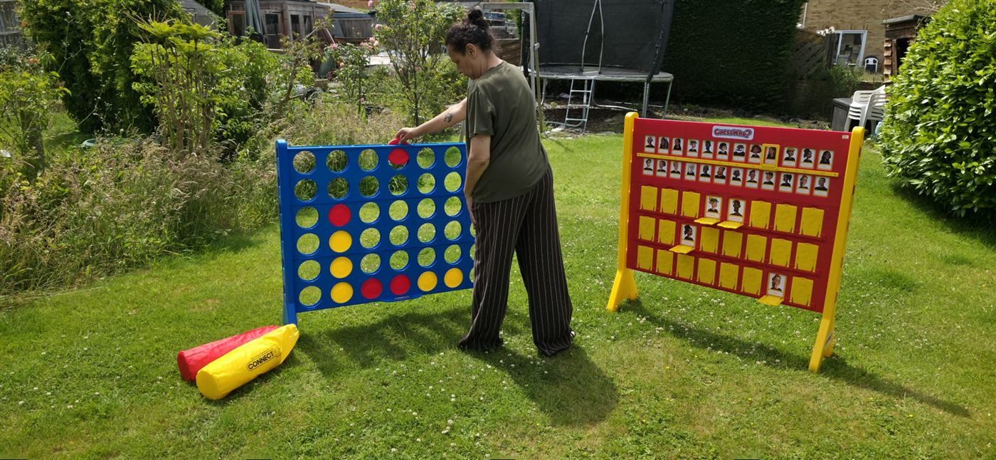 Setting up giant Connect Four and Guess Who in a garden