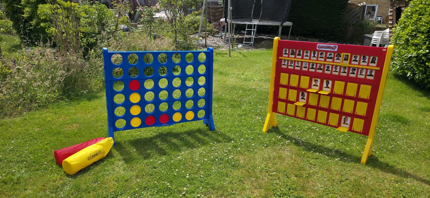 Giant Connect Four and Guess Who set up on a sunny lawn