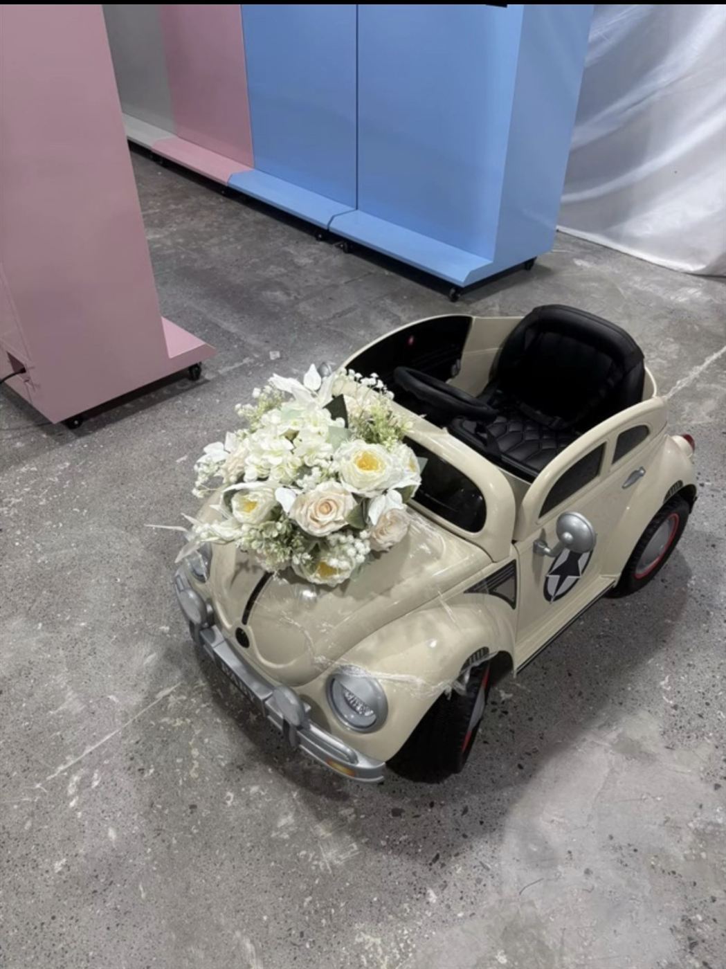 The cream Just Married Beetle car with white roses from our crazy golf course